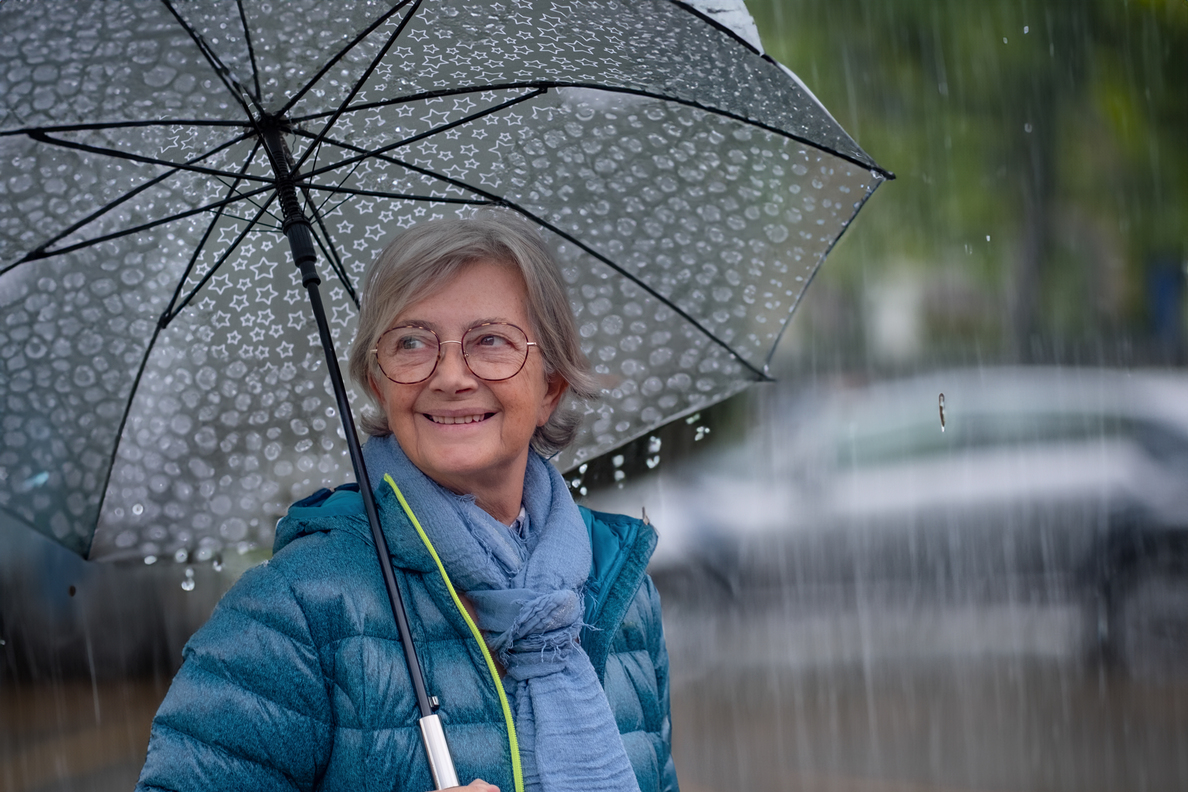 Donna felice sotto la pioggia